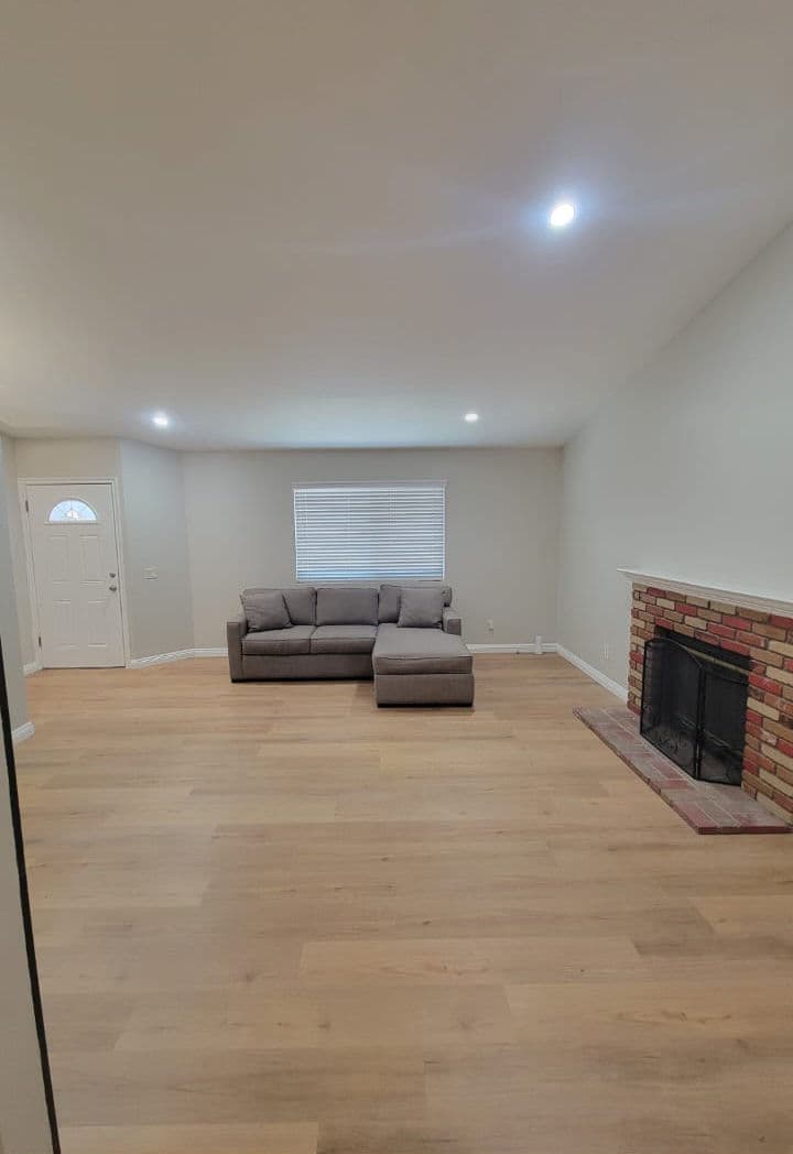 Modern living room with a gray sectional sofa, natural light, and a cozy fireplace.