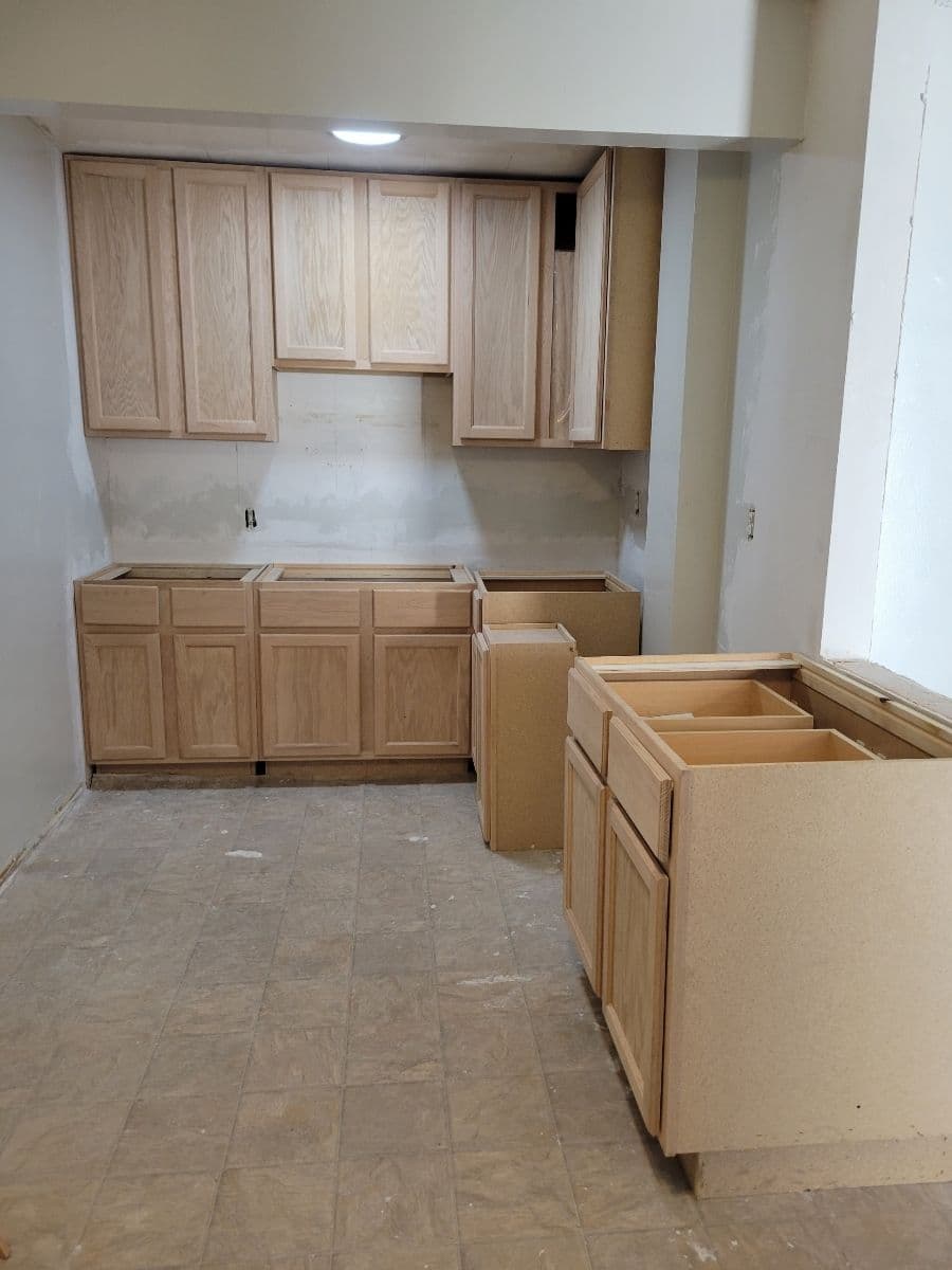 Unfinished kitchen remodel featuring wooden cabinets and empty countertop space.